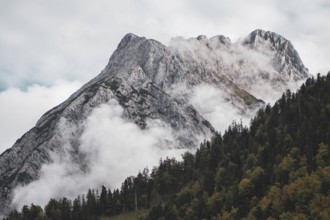 Eng, Tyrol, Austria, Rocky mountains, surrounded by fog and clouds, forest on the slopes