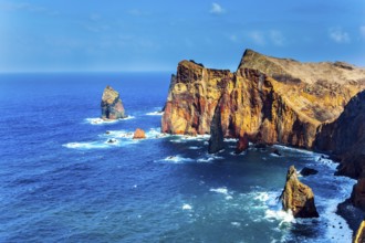Island in the Atlantic. The coast of the island of Madeira - red rocks, azure surf. The blinding