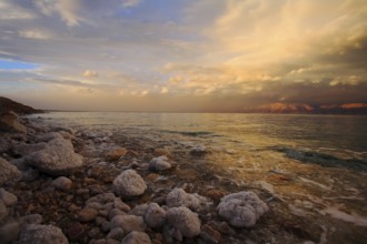 Coast of the Dead Sea in Israel in a spring thunder-storm. The coastal stones covered by salty