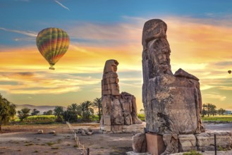 Hot air balloons and Colossus of Memnon in Luxor at sunrise, Egypt