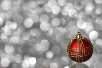 Red Christmas ball on silver blurred background
