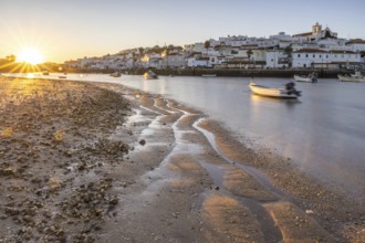 Sunrise with view over a beach and harbour basin at low tide. Panorama picture of a historic old