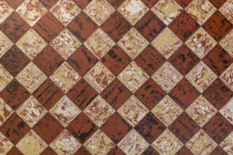 Old-fashioned antique brown beige floor tiles in a characteristic old farmhouse in the Netherlands