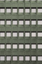 Building facade with a green grid pattern and square windows, in Rotterdam, South Holland,
