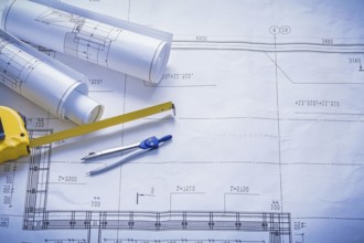 Two rolled blueprints tapeline compass with copyspace construction concept