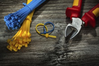 Plastic cables cutting pliers on vintage wooden board