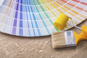 Paint brush roller and color palette on wood board