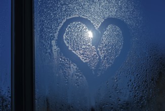 Moonlight through the window. Sweaty glass and heart shape