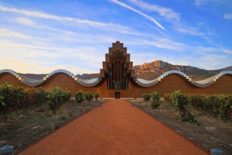 The magnificent modern architecture of Bodegas Ysios. Bright flaming colors of the sunset. Journey