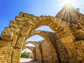 Dazzling spring sun illuminates the ancient Mediterranean port. The remains of the covered arcades