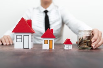 Save for home. Saving money for house and real estate. Woman hand protecting on stack coins and