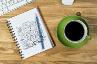 Notepad with idea sketches coffee cup keyboard and pencil on wooden table