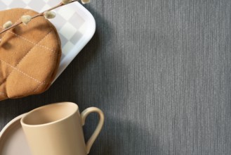 Kitchenware mug cup, dish, gloves, tray on gray fabric background. top view, copy space