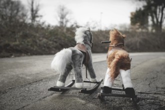Abandoned rocking horses on the road. Concept of abandonment, loneliness, the end of childhood