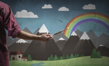 Close up artist hand holding paintbrush. Painter in shirt standing on background colorful picture.