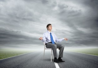 Businessman sitting on an office chair, meditation and calmness