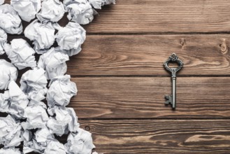 Concept of success and opportunity with old key among paperballs