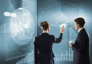 Rear view of businessman and businesswoman working with virtual panel interface