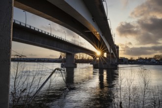 A road or motorway leads through an old historic city gate. Sunset in the evening over the Rhine