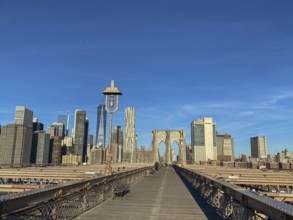 Straight view of the Brooklyn Bridge with skyscrapers and clear sky in the background, New York,