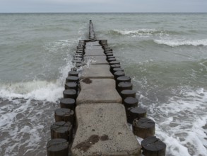 A wooden breakwater extends into the sea, surrounded by water and waves, ahrenshoop, zingst,