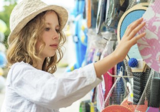 Little girl is choosing table tennis racket for vacations
