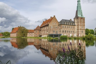 An old castle with a striking tower, reflected in a calm lake, Raesfeld, westphalia, germany