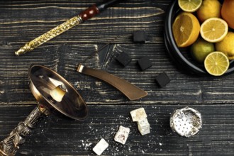 Stylish Smoking hookah and basket with lemon, lime and orange on wooden background. Top view. Flat
