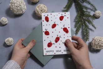 Reindeer fingerprints Sustainable Christmas preparation female hand holding handmade greeting cards