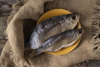 Two dried fish - rudd lie on a canvas napkin