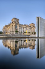 The Reichstag in Berlin at dusk, reflected in the River Spree