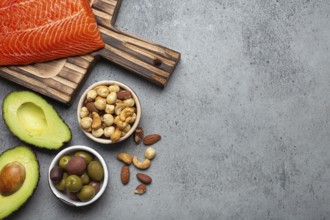 Food sources of healthy unsaturated fat and omega 3: fresh raw salmon fillet, avocado, olives, nuts