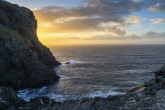 Long exposure sunset seascape with rocks and reef at Capo Falcone in Sardinia