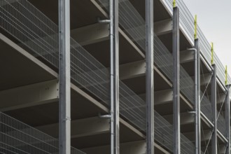 Modern parking garage levels with metal grid railing and support structure