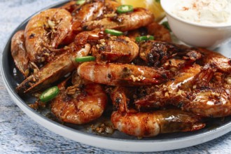 Grilled shrimps served with hot sauce and slices of fresh lemon, homemade, no people