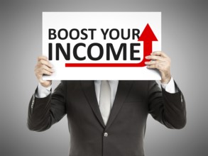 A business man holding a paper in front of his face with the text boost your income