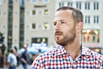 An image of a handsome man with a beard in the city