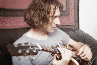 An image of a man playing the guitar
