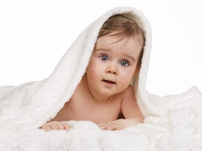 Small astonished child baby wrapped in blanket