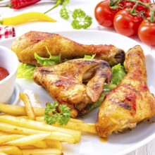 Grilled chicken wings, legs, chips and vegetables