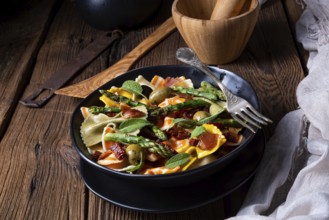 Pasta salad with green asparagus, olives and Parma ham