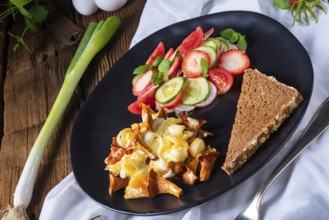 Fresh chanterelles with scrambled eggs and a green salad