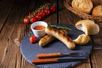 Rustic bratwurst with ketchup and fresh rolls