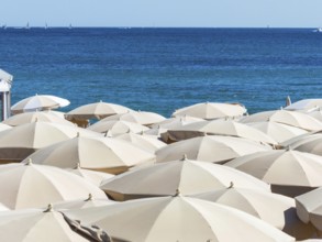 Many sunshades on the beach, symbolic photo for holidays, mass tourism, sunburn Austria