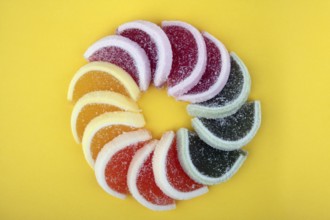 Bunte Geleefrucht isoliert auf gelbem Hintergrund