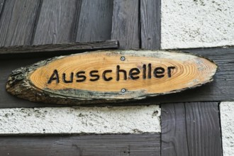 Wooden sign with Ausscheller lettering on a wooden beam