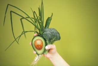 Unrecognizable female demonstrating bunch of healthy fresh vegetables while being on diet against