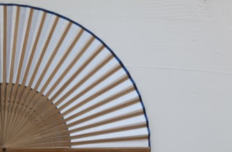 Typical Japanese hand fan made on the wooden white table