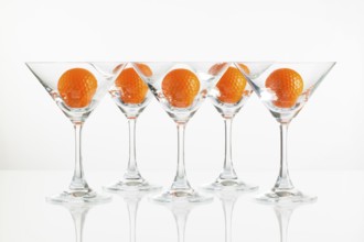 Five glasses of champagne and golf equipments on the glass desk