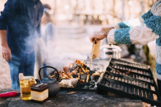 The guy fries a shish kebab on an open fire on a brazier